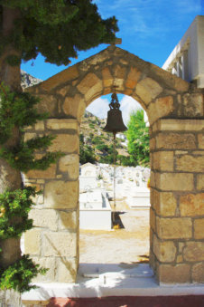 Poort met bel bij de begraafplaats in Menetes op Karpathos Griekenland