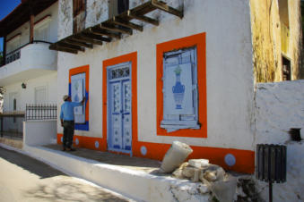 Schilder de gevel aan het schilderen in Piles op Karpathos Griekenland