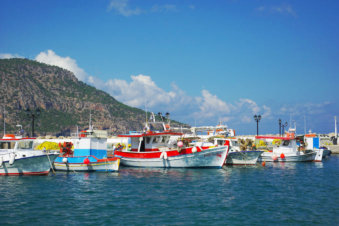 Als op een schilderij liggen de kleurrijke vissersbootjes aan de pier